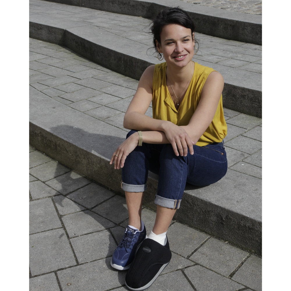 
                  
                    Woman sitting and wearing the All Round Shoe by DARCO
                  
                